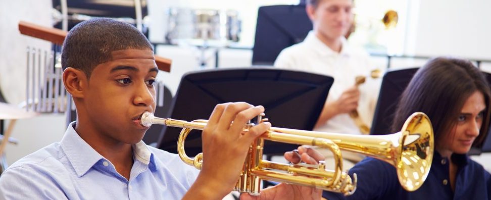 Male Pupil Playing Trumpet In High School Orchestra